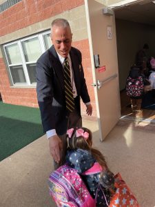 Safety Services Guard Joe Trabucco greets preschool students at morning dropoff.