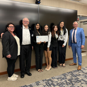 group of students posing with large check