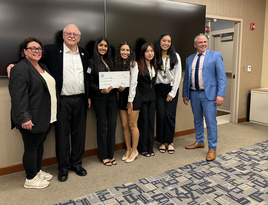 Group of students posing with a giant check