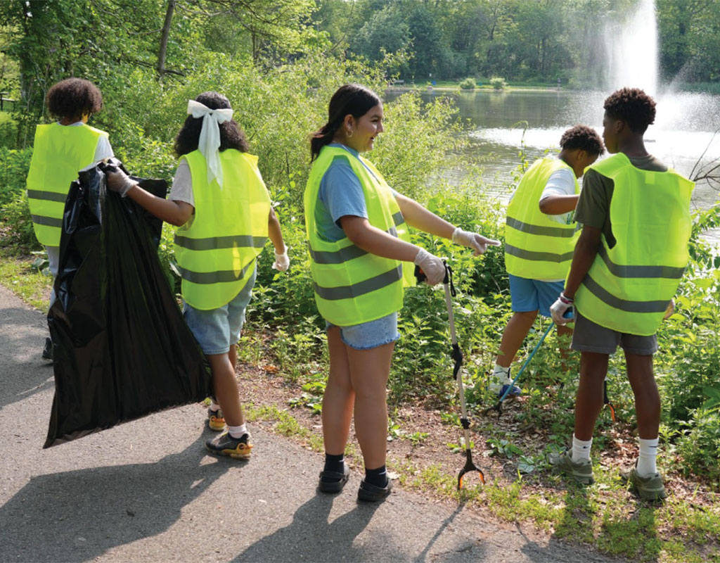 students out in a park in vests collecting trash