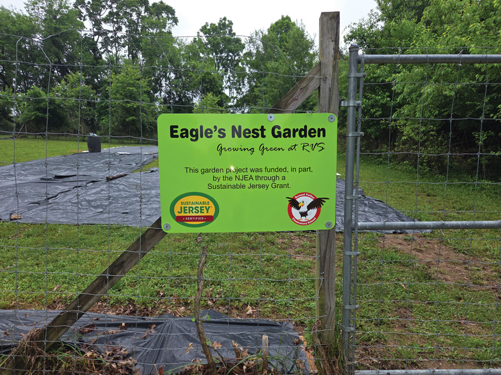 gate with a sign in front of a garden
