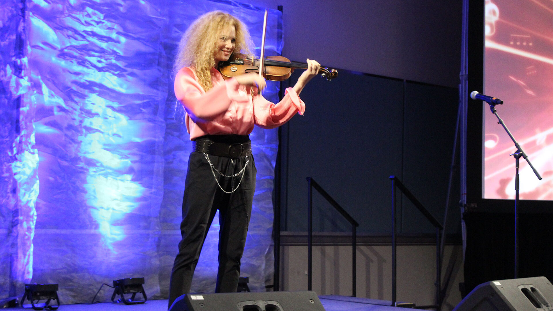 Miri Ben-Ari performing with violin at her keynote address at workshop 2025