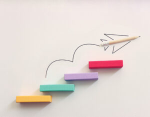 colorful blocks steps with a hand drawn pencil airplane climbing