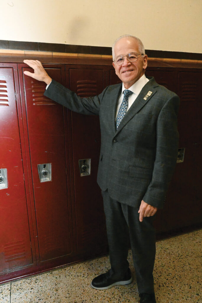 NJSBA President Michael Jacobs poses in front of lockers in a school hallway