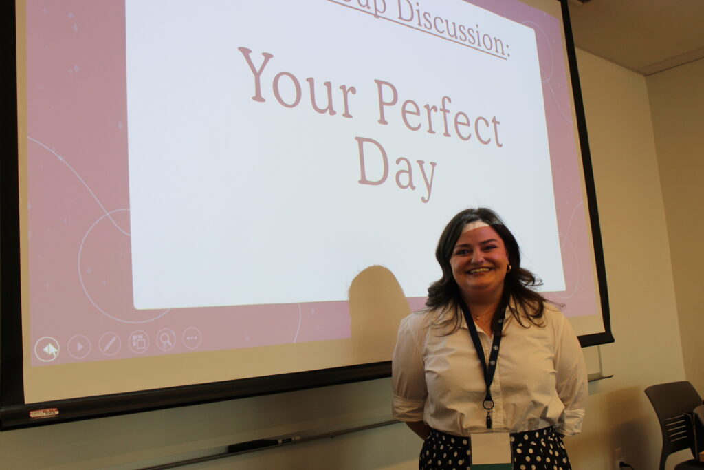 Grace Flagler posing for photo in front of projector screen