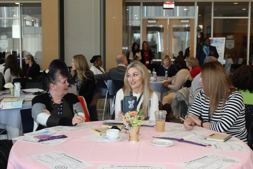 Women's Leadership attendees sitting down conversing in main hall